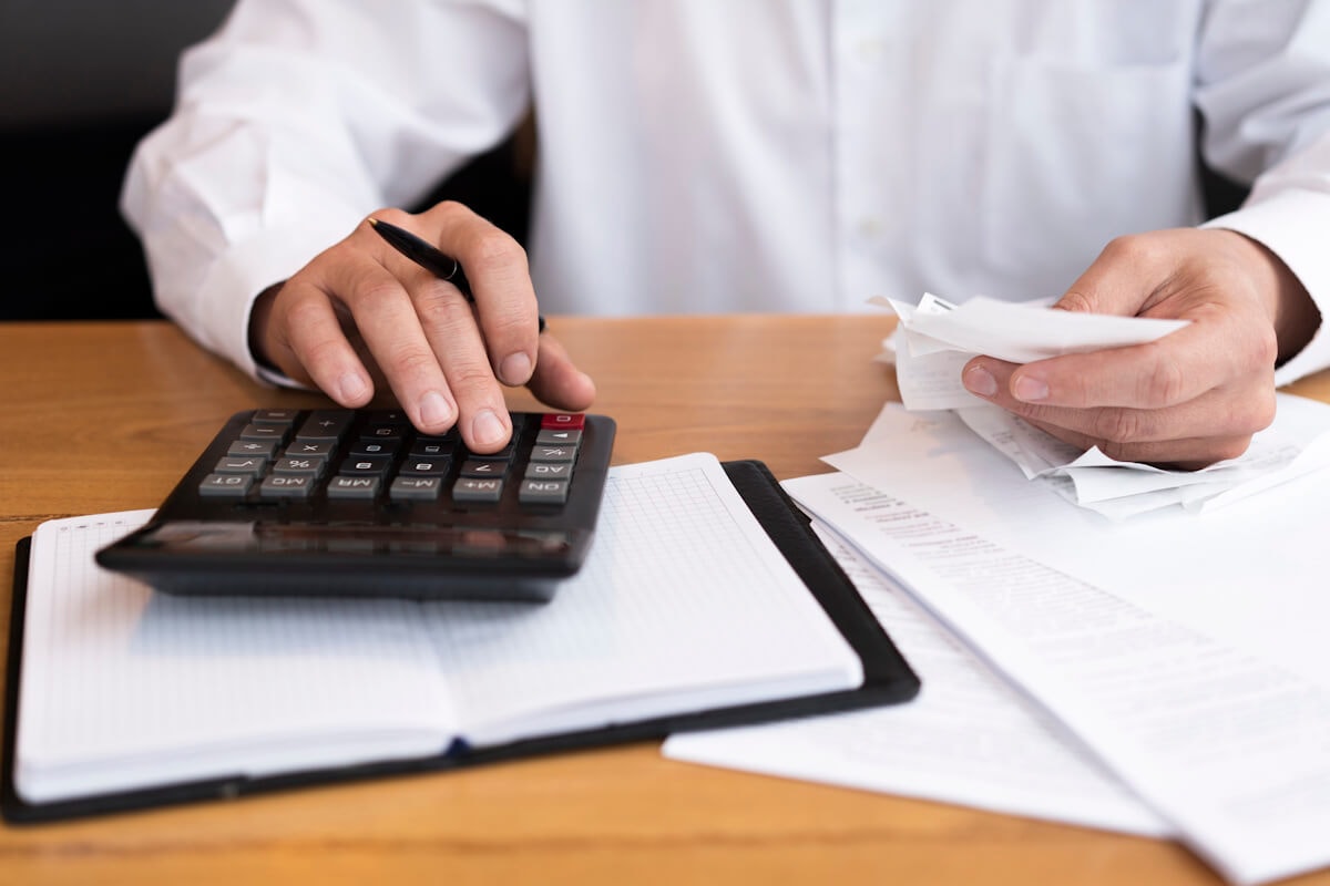 Businessman Calculating Expenses with Receipts